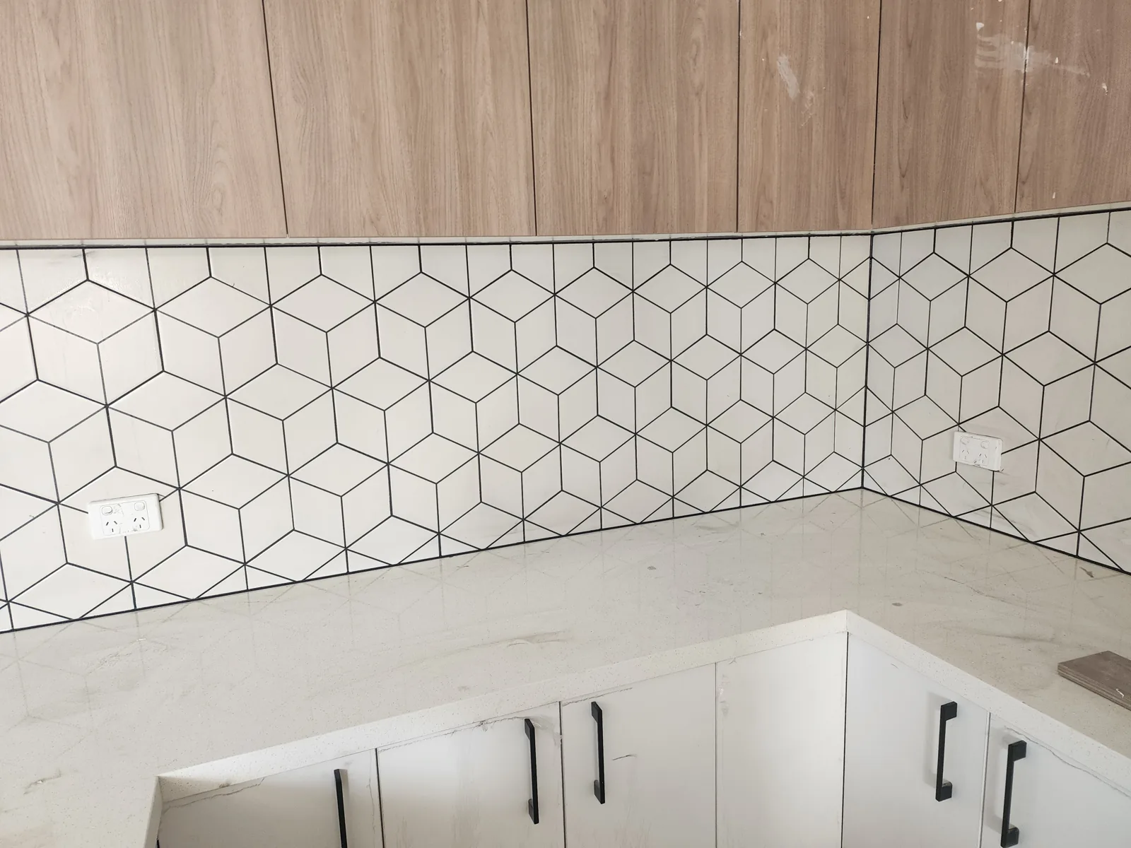 White geometric tiled kitchen splashback with clean caulked joints, Melbourne